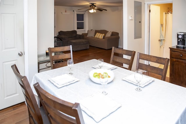 dining space featuring electric panel, a ceiling fan, and wood finished floors