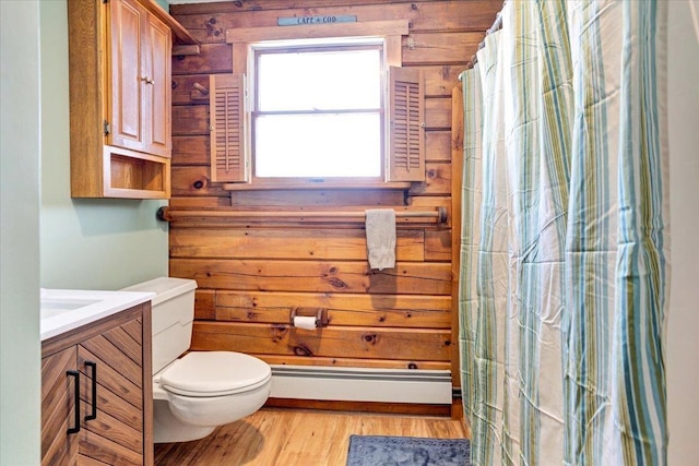 bathroom featuring curtained shower, toilet, baseboard heating, wood finished floors, and vanity