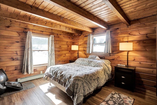 bedroom with a baseboard radiator, multiple windows, beam ceiling, and wood finished floors