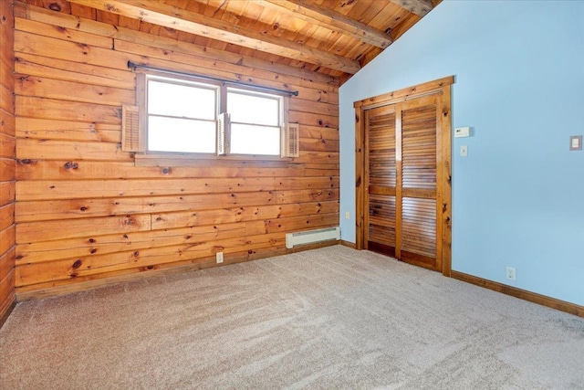 spare room featuring lofted ceiling with beams, wood ceiling, wood walls, a baseboard heating unit, and carpet flooring