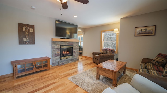 living area featuring baseboards, recessed lighting, a fireplace, wood finished floors, and a ceiling fan