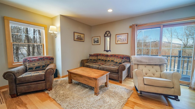 living room featuring recessed lighting, baseboards, and light wood-type flooring