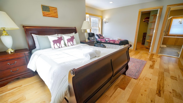 bedroom featuring a spacious closet, recessed lighting, a closet, and wood finished floors