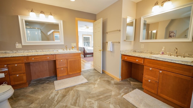 ensuite bathroom with connected bathroom, baseboards, and vanity