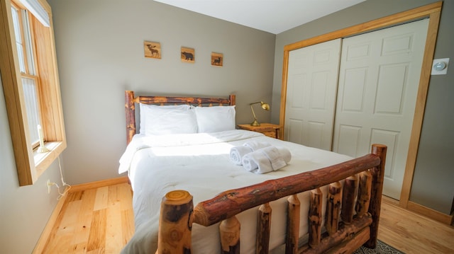 bedroom with a closet, baseboards, and wood finished floors