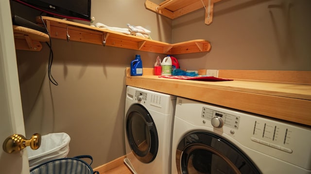 clothes washing area featuring laundry area, washing machine and dryer, and baseboards