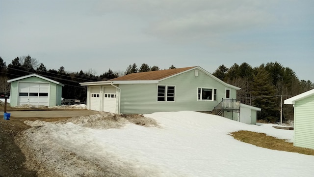 view of front of house with a garage and an outbuilding