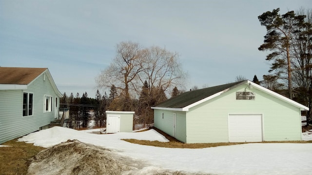 view of snow covered exterior with an outbuilding