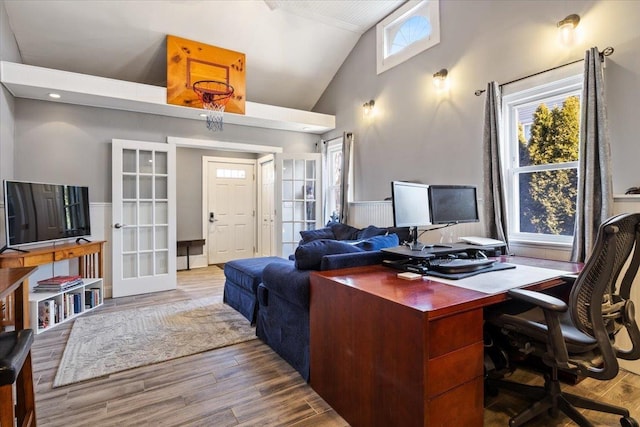 office area with wood finished floors, french doors, and high vaulted ceiling