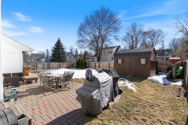 view of patio / terrace with outdoor dining area, a fenced backyard, an outdoor structure, grilling area, and a storage shed