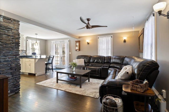 living room featuring ceiling fan, french doors, beam ceiling, and dark wood finished floors