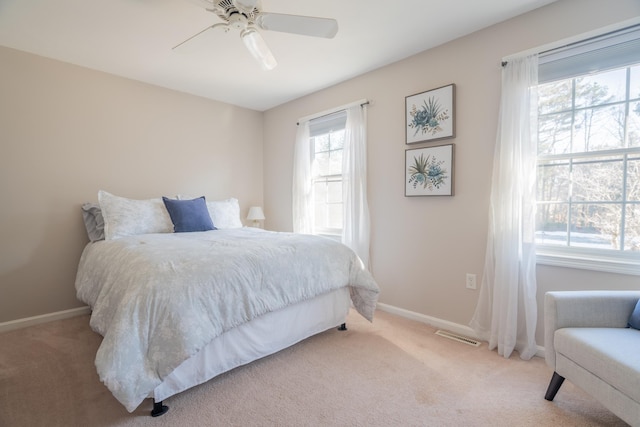 carpeted bedroom featuring visible vents, ceiling fan, and baseboards