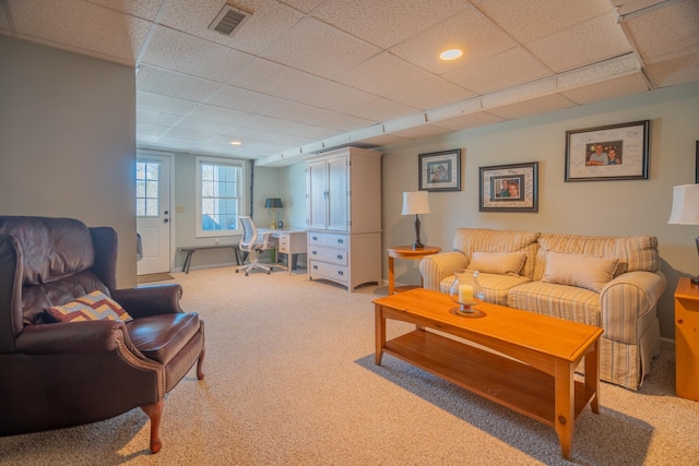 living area featuring light colored carpet, visible vents, and a drop ceiling