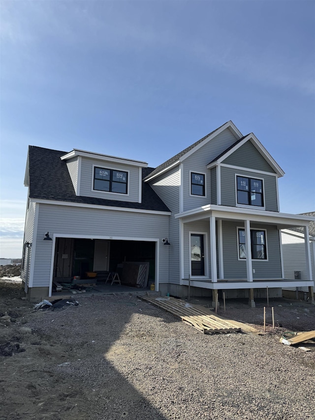 view of front of home with a garage, driveway, and a shingled roof