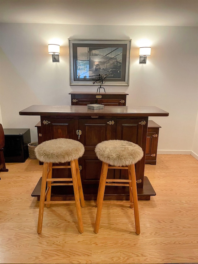 bar featuring light wood finished floors and baseboards