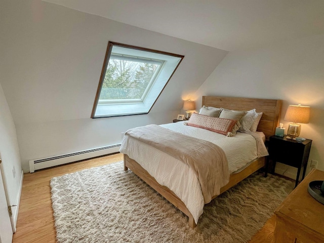 bedroom with wood finished floors and baseboard heating