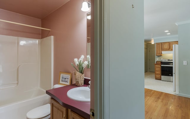 full bathroom featuring vanity, wood finished floors, ornamental molding, bathing tub / shower combination, and toilet