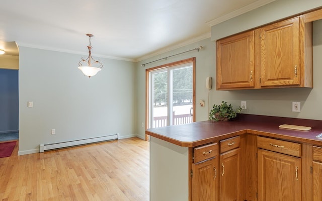 kitchen featuring a baseboard radiator, dark countertops, crown molding, and light wood finished floors