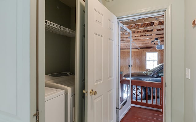 clothes washing area with dark wood-type flooring, separate washer and dryer, and laundry area