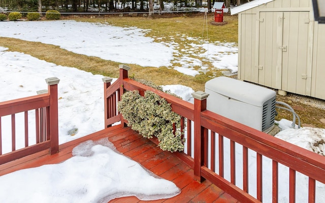 snow covered deck featuring an outbuilding