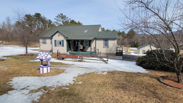 snow covered rear of property with a shingled roof