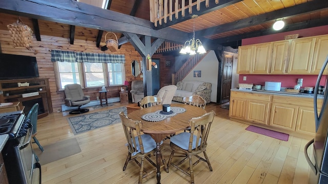 dining area with wood walls, beam ceiling, light wood-style flooring, wooden ceiling, and an inviting chandelier