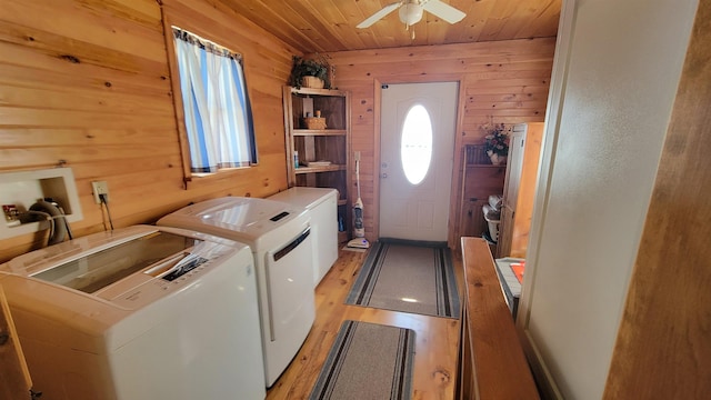 laundry room featuring wooden walls, light wood-type flooring, laundry area, wooden ceiling, and independent washer and dryer