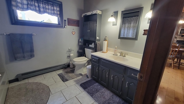 bathroom with vanity, tile patterned floors, toilet, and baseboard heating