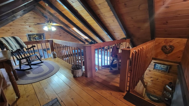 living area featuring wooden ceiling, wooden walls, hardwood / wood-style floors, and vaulted ceiling with beams