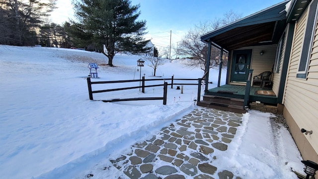 snow covered deck featuring fence