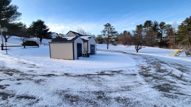 snow covered structure featuring an outbuilding