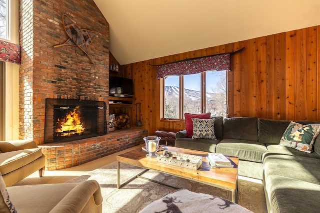 carpeted living area with high vaulted ceiling, wood walls, and a fireplace