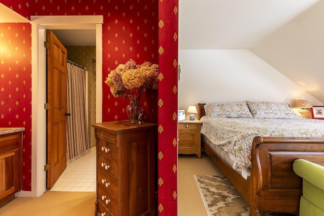 bedroom with wallpapered walls, vaulted ceiling, and light colored carpet