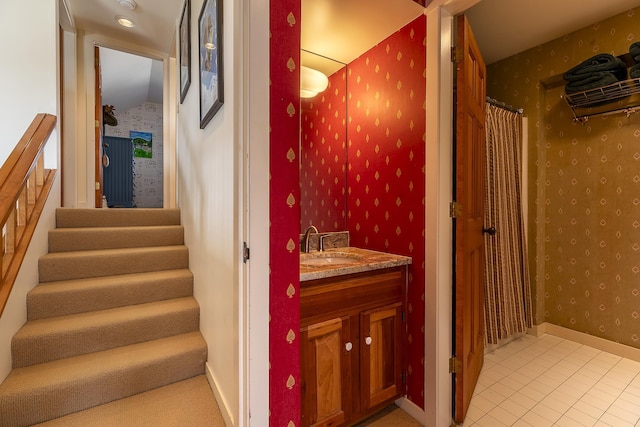 interior space featuring tile patterned flooring, baseboards, vanity, and wallpapered walls