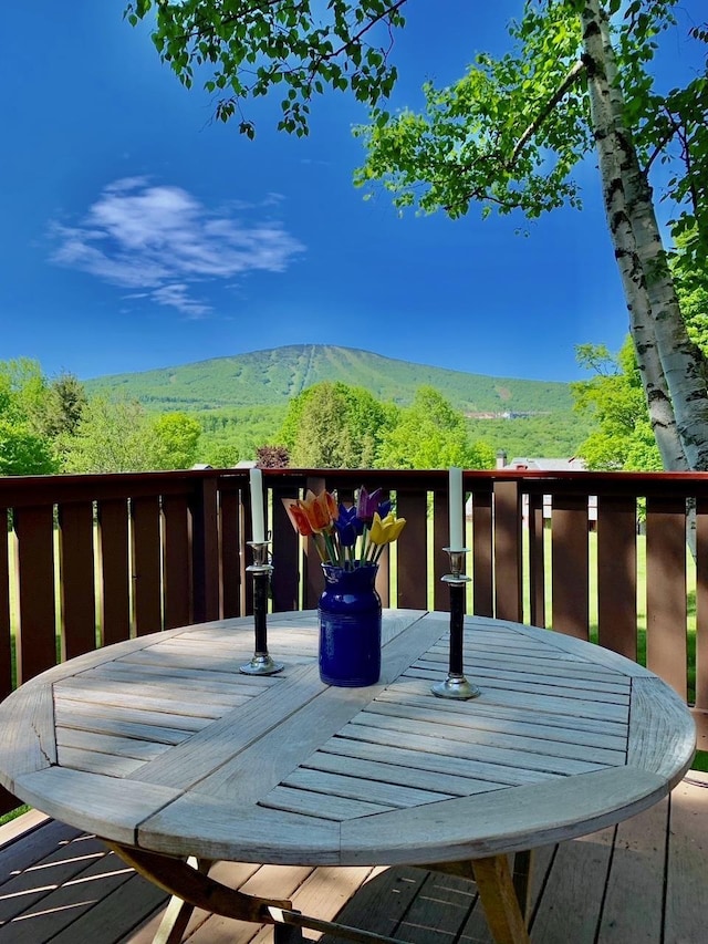wooden terrace with a mountain view and outdoor dining area