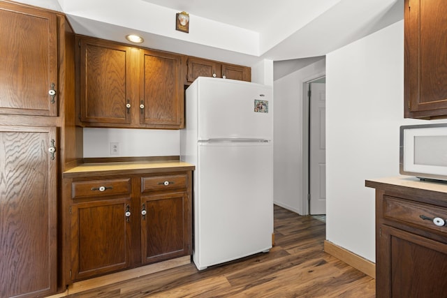 kitchen featuring light countertops, wood finished floors, baseboards, and freestanding refrigerator