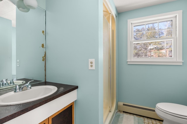 bathroom featuring toilet, vanity, and a baseboard heating unit