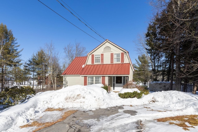 colonial inspired home featuring metal roof, a gambrel roof, and a standing seam roof