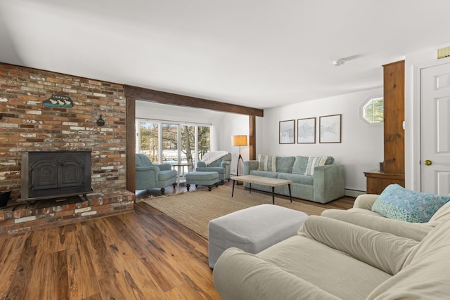 living area with a baseboard heating unit, plenty of natural light, wood finished floors, and a wood stove