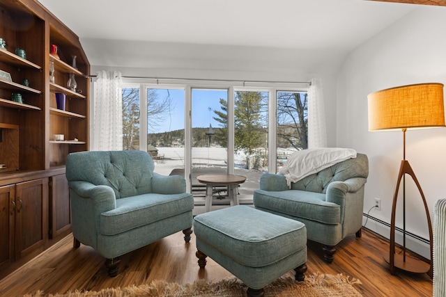 sitting room with a baseboard heating unit, vaulted ceiling, and wood finished floors