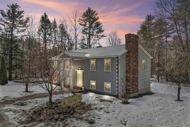 split foyer home with a chimney and metal roof