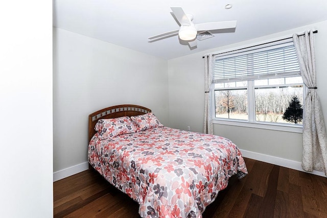 bedroom with visible vents, baseboards, wood finished floors, and a ceiling fan