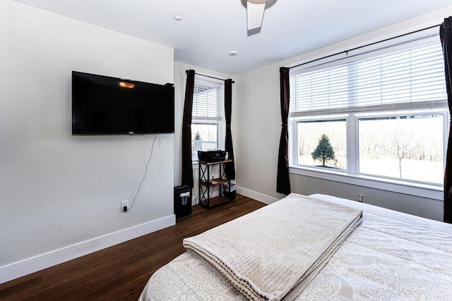 bedroom featuring ceiling fan, baseboards, and dark wood-style flooring