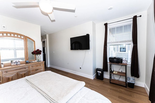 bedroom featuring dark wood finished floors, a ceiling fan, and baseboards