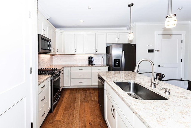 kitchen with dark wood finished floors, a sink, white cabinets, appliances with stainless steel finishes, and backsplash