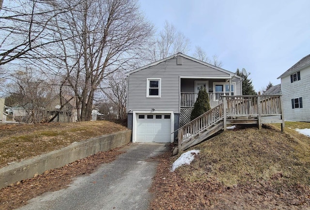 view of front of property with aphalt driveway, stairway, an attached garage, and a porch