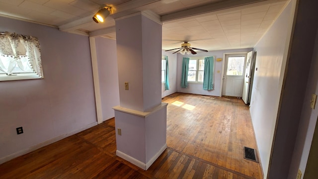 spare room featuring hardwood / wood-style floors, baseboards, visible vents, and ceiling fan