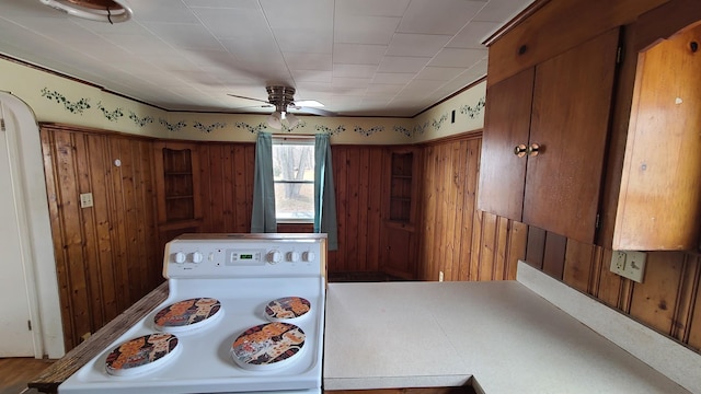 kitchen featuring brown cabinetry, ceiling fan, and white electric range oven