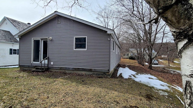 back of house featuring a yard and entry steps