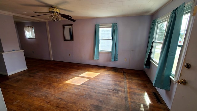 spare room with a ceiling fan, visible vents, and wood-type flooring